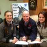 Raymond Bready of Pegus Horse Feeds with Kirsty and Courtney Stuart discussing prizes for the indoor eventing league