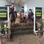 Sarah Kileen & Charley (drew Mackins Horse Feed voucher), Katie O' Hare & Blaney Boy and Ally Herr & Thunder pose for the camera after prize presentation of the 60cm class at Ravensdale Lodges indoor arena eventing league