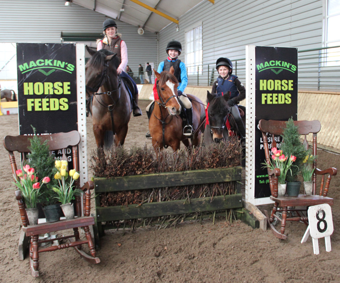 Sarah Kileen & Charley (drew Mackins Horse Feed voucher), Katie O' Hare & Blaney Boy and Ally Herr & Thunder pose for the camera after prize presentation of the 60cm class at Ravensdale Lodges indoor arena eventing league