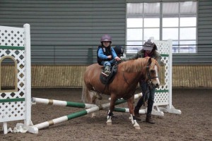 Two year old, Todd Martin from Newcastle Co. Down gets a helping from his mother and sister as he attends his first ever show and competes in the cross poles class at Ravensdale Lodge riding hero on Friday evening.