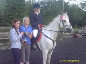 Clodagh Barry & Mervyn winners of the 1 metre class receiving the Omagh Equestrian & Countrywear Perpetual Cup from Lisa Patterson & Sheelagh McCrory on behalf of Ann Patterson