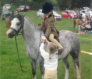 Lucy Kayes and her pony Ruby show off their First Ridden class first prize to a young friend at the Lessans Kids Gymkhana 