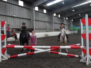  Naomi Cavana on Molly and Oliver Doherty on Bella receiving their red rosettes for double clear rounds in the 60 cm class