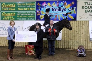 Kerrie Rafferty & "Cor Rambler" won €650 of the €1300 charity prize fund by winning league titles in both class 1 & 2 in the O' Reillys Wholesalers Newry indoor charity dressage league. Kerri is pictured with judge David Patterson & Maureen Magennis of sponsors O' Reillys Wholesalers Newry who presented the winning cheque for €650 to Elaine Murray on behalf of Ward 10 North, Belfast City Hospital. Photo: Niall Connolly.