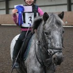 PJ and Emma Bamford hold up their blue rosette. Photo by Equi-Tog