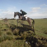 Hunt Master Ian Holmes clears the fence on Pancho