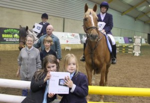 "Smart Fever", three of the five hi-tech smart tablets on offer over the weekend at Ravensdale Lodge were handed out on Friday night. Pictured are Georgia Kirkwood & Debonair (leading points combination for Friday's horse & pony training league), Kate Kenwright & Storm (leading combined leagues points combination), Eve & Rosalyn Connolly who collected the tablet on behalf of Kayla Mc Entaggart whose name was drawn out of the hat of qualified combinations on Friday night. Also pictured is Derek Kirkwood, judge Noleen Johnston who made the draw and Jason Connolly of Ravensdale Lodge.