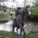 Hunt Master Ian Holmes leads the hunt out of the river