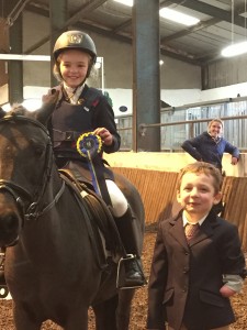 Omagh Group RDA rider Cian Arthur assists with the Prize giving, presenting a rosette to Amy McLaughlin and Cookie Crisp at the group's recent Pix and Mix competition.