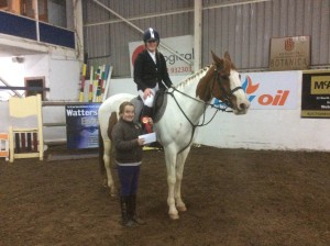 Jessica Morgan and Troy winners of the 1.20m class being presented with their rosette and voucher by Katie Creegan.