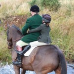 Hunt Master Ian Holmes Gives Maria Carr a lift across the river