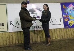Sinead Young capped a fine 12 week indoor horse & pony training league by winning the leading points combination prize. Sinead who rode her own Jacobi in the 80cm & 90cm classes is seen here being presented with her smart tablet prize by her father Michael. Photo: Niall Connolly.