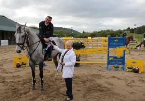 "Presentation time": Local favourite, John Floody who is seldom out of the rosettes at Ravensdale Lodge managed to slot Matthew Birch's Mise Le Meas into fifth place in the National Grand Prix on Sunday afternoon with a clear round jump off time of 38.66 seconds. Floody is seen here being presented with his prize from International judge Hillary Mc Cleland. Photo: Niall Connolly. 